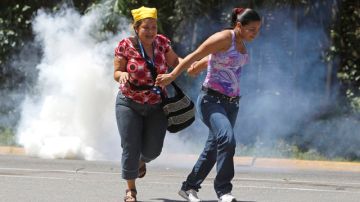 Familiares de reos de El Rodeo I huyen de gases lacrimógenos lanzados por Guardia Nacional venezolana, un año atrás.