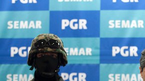 Marines mexicanos flanquean a Eric Jovan Lozano Díaz, alias 'El Cucho', a quien presentan ante  la prensa.