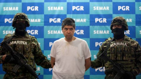 Marines mexicanos flanquean a Eric Jovan Lozano Díaz, alias 'El Cucho', a quien presentan ante  la prensa.