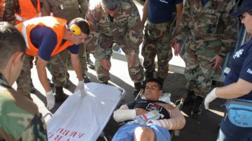Un agente de la policía herido en una disputa por tierras espera para ser trasladado a un hospital, tras llegar al aeropuerto de Asunción,