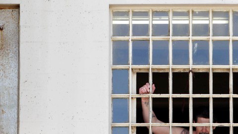 Un reo mira por la ventana de la Deuel Vocational Institution de Tracy California.