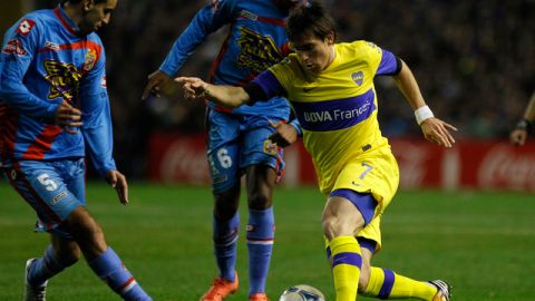 Pablo Mouche (7) intenta la maniobra ante Jorge Ortiz (5) y Carlos Carbonero en un trámite del partido de ayer en La Bombonera.
