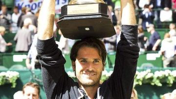 El alemán Tommy Haas levanta su trofeo Gerry Weber tras derrotar al suizo Federer por 7-6 (5), 6-4 en la final del torneo de Halle.