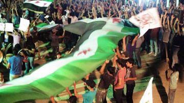 Opositores al Gobierno sirio realizaban ayer una protesta alegando que grupos armados quieren impedir las evacuaciones en Damasco.