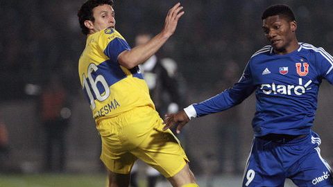 Junior Fernandes (der.) de la Universidad de Chile supera la marca de Pablo Ledesma (izq.), de Boca Juniors en el juego que terminó sin goles.
