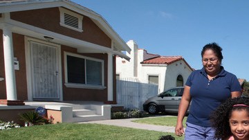 Sheyla Menzie con sus hijos Azzel, 13, Emely, 6, y Gerson, 4, juegan felices frente a su nueva casa.