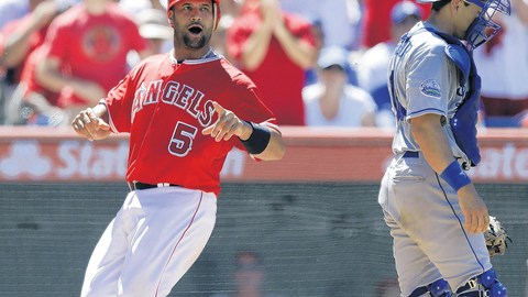 Albert Pujols celebra en home ante Matt Treanor luego de anotar carrera con sencillo de Mark Trumbo en la séptima entrada.