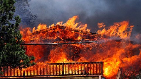 Un bombero lucha por apagar las llamas  que consumen una casa en Estes Park, Colorado.