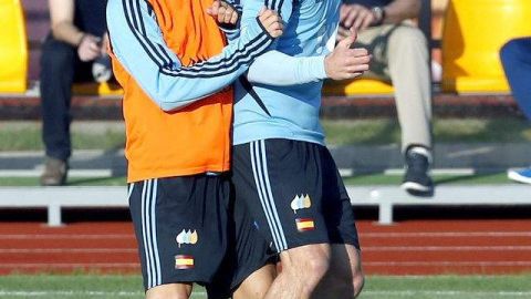 Cesc Fábregas (izq. ) y Xavi Alonso pelean por el balón.