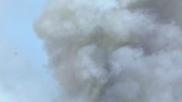 Un fuego, no controlado aún, quema parte de un bosque detrás de estas casas, al oeste de Colorado Springs, en Colorado, ayer.