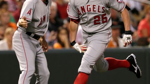 El coach de tercera de Angels, Dino Ebel (izq.), felicita a Peter Bourjos, quien conectó un jonrón de dos carreras en el sexto ante Baltimore.
