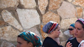 Mujeres judías observan a los  empleados  que fueron contratados por el Gobierno para remover  pertenencias del que había sido el hogar de estas en Israel.