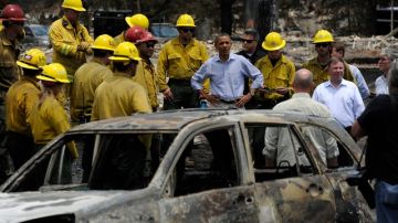 El presidente Obama hablaba con  bomberos al recorrer una zona devastada de Colorado Springs, ayer.