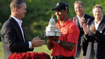 Tiger Woods (c) recibe el trofeo de manos de Rob Forsyth, vicepresidente y gerente general de AT & T Mobility.