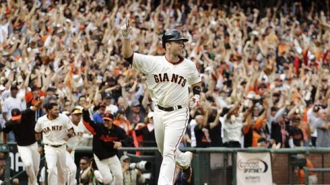 Buster Posey celebra después del cruzar el home con la carrera del triunfo impulsado por el batazo decisivo del boricua Ángel Pagán.