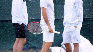 Roger Federer (izq.) conversa con su coach en la práctica de ayer.