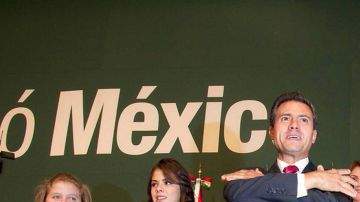 Enrique Peña Nieto al comenzar a celebrar la victoria anoche, mientras en la parte de atrás se observa a su esposa, la actriz Angélica "La Gaviota" Rivera y sus hijas.