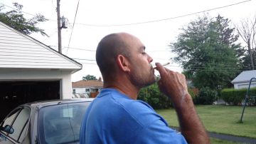 Demetrio Guerrero fuma afuera de su casa en Chicago Heights