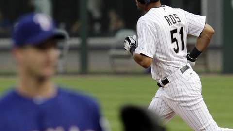 El boricua Alex Ríos, de los Medias Blancas, recorre las bases luego de haber  descargado jonrón a Roy Oswalt (izq.) en el primer inning.