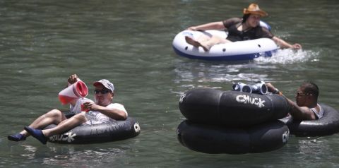 Beber cerveza mientras los bañistas flotan plácidamente por el río en New Braunfels es una tradición para cientos de miles de turistas que visitan el lugar cada verano.
