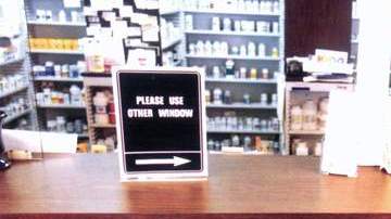 Un hombre frente al mostrador de una farmacia en Nueva York escoge una medicina para su compra.