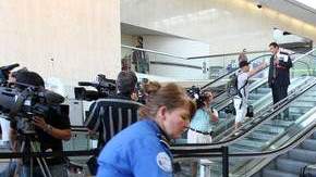 Agentes del aeropuerto hacen pasar  el equipaje por una máquina de rayos x para ver si hay  armas.