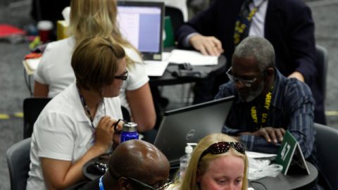 Tressa Miller (d), ayuda al veterano de guerra Roger Porter a buscar empleo en un centro de trabajo de Detroit, Michigan.