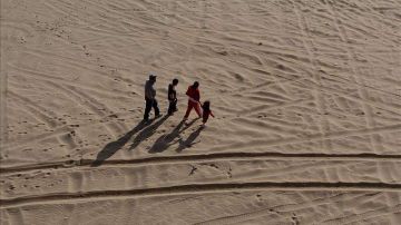 Una familia de inmigrantes camina por el desierto que separa México y Estados Unidos.