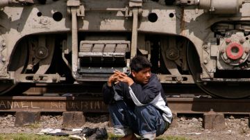Un migrante ve pasar un tren en México.