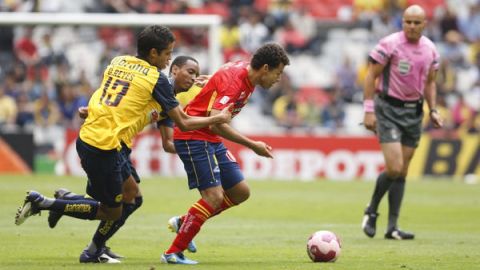 Miguel Sabah (der.) delantero del Morelia escapa a la marca de dos jugadores del América duante la fecha doce del torneo mexicano.