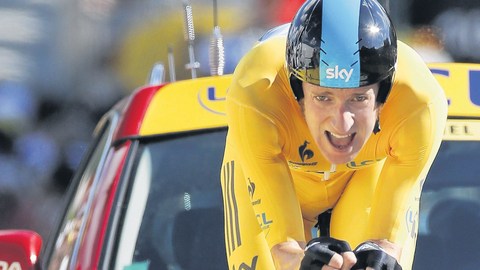 Bradley Wiggins se encamina hacia la meta escoltado por un auto.