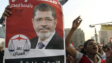 Seguidores del electo presidente Mohamed Morsi muestran carteles en la plaza Tahrir en El Cairo, durante una protesta realizada ayer.