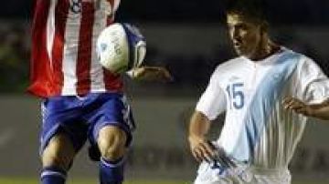Jorge Mendoza (izq.) de Paraguay intenta pasar frente a  la marcación de  Manuel León de Guatemala.