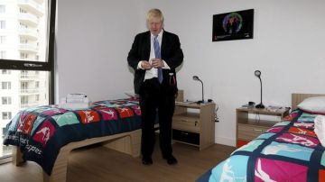 El alcalde de Londres, Boris Johnson, observa los preservativos que se dejan en las habitaciones de los atletas en la villa olímpica.