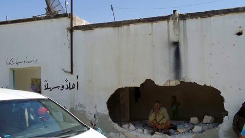 Varias personas observan los daños registrados tras un ataque en la localidad siria de Tremseh, provincia de Hama, Siria, ayer.