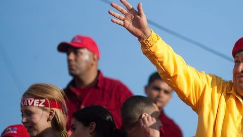 El presidente de Venezuela, Hugo Chávez (d), saluda a sus seguidores en un acto.
