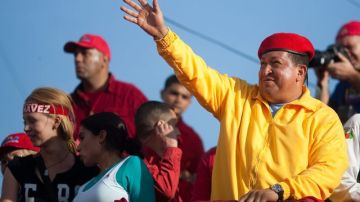 El presidente de Venezuela, Hugo Chávez (d), saluda a sus seguidores en un acto.