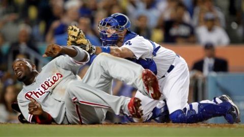 Ryan Howard de los Filis y A.J. Ellis de los Dodgers voltean a esperar la decisión del Umpire.