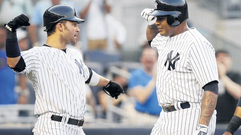Andruw Jones (centro) es felicitado por  Robinson Canó (der.) y  Nick Swisher, a quienes impulsó con un jonrón en el segundo inning.