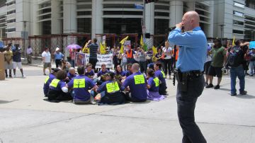 Activistas protagonizan en calles del centro de Houston una sentada en apoyo a los trabajadores de limpieza en huelga.