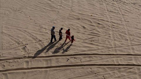 Una familia de inmigrantes camina por el desierto que separa México y Estados Unidos.