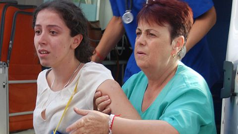 Israelí no identificada es ayudada al llegar al hospital. .
