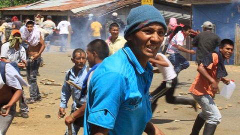 Manifestantes retan a la policía desde una barricada,  para exigirle a los militares que se marchen del área de Caloto, Colombia.