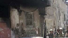 Soldados del ejército sirio, leales a Bachar Al Asad, gritaban ayer con fusil en mano en el barrio de Midan, en Damasco, Siria.