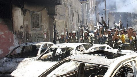 Soldados del ejército sirio, leales a Bachar Al Asad, gritaban ayer con fusil en mano en el barrio de Midan, en Damasco, Siria.