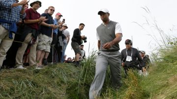 Tiger Woods camina con paso firme y decidido seguido de sus ayudantes y respaldado con aplausos de sus fanáticos.