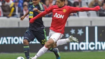 Javier 'Chicharito' Hernández del Manchester United se disponer a rematar seguido por Aidan Jenniker, del Ajax.