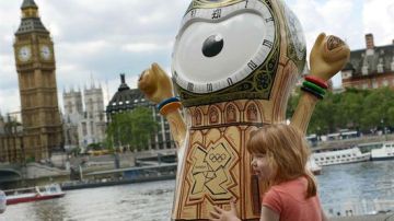 Una niña posa con la mascota olímpica junto al Parlamento británico.
