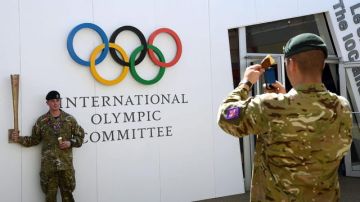 Estos soldados, parte del aumento de efectivos que vigilarán los Juegos en Londres, aprovechan para tomar la foto del recuerdo.