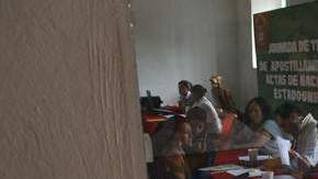 Niños estadounidenses observan como varias familias tratan de obtener el sello mexicano en los certificados de nacimiento de EEUU.